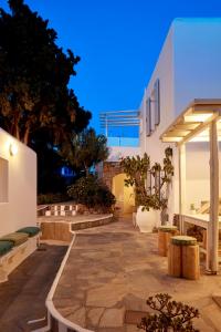 米克诺斯城Mykonos Town Suites的白色建筑的庭院,种植了盆栽植物
