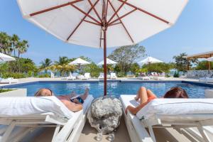 珀拉什奇亚Naïa Resort and Spa的一群人躺在游泳池旁边的床上