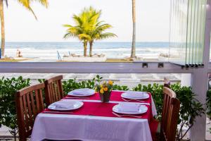 瓜鲁雅Strand Hotel Guarujá Frente Mar的一张桌子,配有红色桌布,享有海滩美景