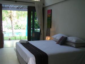 甘地达萨水族生态度假酒店的卧室设有一张白色大床和一扇窗户。