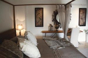 法萨诺Masseriola Antiche Fogge的卧室配有带枕头和桌子的天蓬床