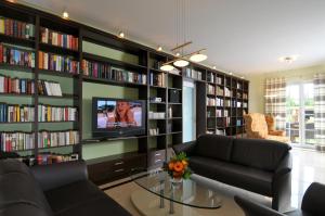 格罗斯施旺湖Villa DUXCAAR的客厅配有沙发,图书馆配有电视
