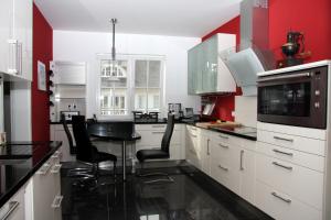 格罗斯施旺湖Villa DUXCAAR的厨房配有白色橱柜和黑色台面