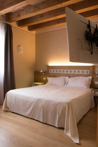 洛迪赛斯蒙内斯酒店的卧室配有一张白色大床
