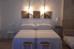 孔卡斯普奇拉马塞里亚塔斯帕蒂旅馆的卧室配有一张墙上有两张照片的床。