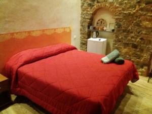斯培西亚五渔村安德里亚旅馆的一间石墙卧室,配有红色的床