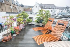 杜塞尔多夫Apartement mit Dachterrasse - bei Curth klingen - Teilen Sie uns Ihre Ankunfszeit mit的大楼内的阳台配有椅子和盆栽植物