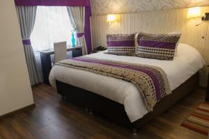 维纳德马LV Hoteles Boutique的一间卧室配有一张带紫色枕头的大床