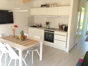 米罗Bootshaus Mirow的厨房配有木桌和白色橱柜。