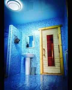 UzynHotel Bannyi Dvor的蓝色瓷砖浴室设有水槽和门