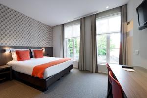 科特赖克方块酒店的酒店客房设有一张床、一张书桌和窗户。