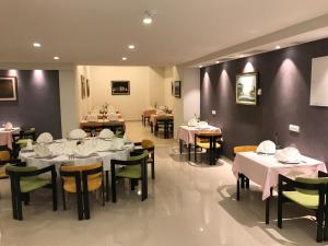 内乌姆太阳酒店的用餐室配有桌椅和白色的桌布