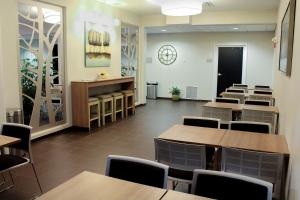 彭延彭延温德姆麦克罗特客栈&套房的餐厅设有桌椅和墙上的时钟