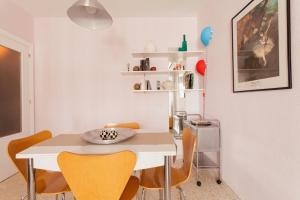 塞维利亚Apartamento Jardin de Santa Paula的一间设有白色桌子和黄色椅子的用餐室