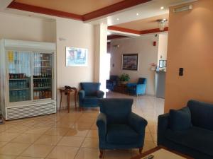 SkaramangásGlaros的一间设有蓝色椅子的等候室和一间药房