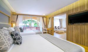 芭东海滩Phuket Graceland Resort and Spa的一间卧室配有一张大床和一台平面电视