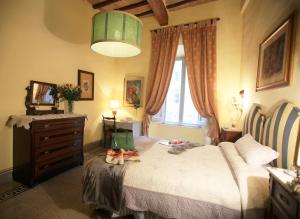 锡耶纳B&B Le Aquile的一间卧室配有带梳妆台和窗户的床。