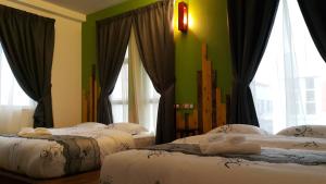 雪邦PI Grand Hotel的配有两张床铺的绿色墙壁和窗户