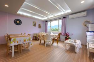 Fengli伊莉莎白小屋民宿的一间带桌椅的用餐室和窗户。