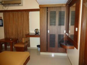 班加罗尔西塔尔住宿酒店的客厅配有木制橱柜和桌子