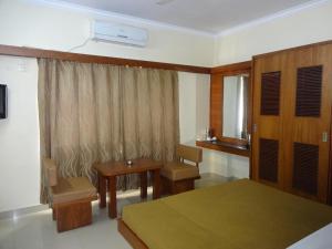 班加罗尔西塔尔住宿酒店的一间卧室配有一张床、一张书桌和一个窗户。
