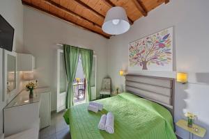 埃尔莫波利斯天堂酒店的一间卧室设有一张绿色的床和一个窗户。