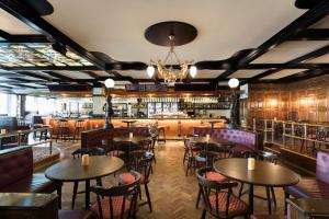 乌普萨拉学院精英酒店的一间带桌椅的餐厅和一间酒吧