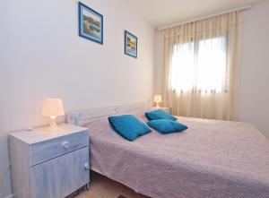 梅杜林Apartments Valeria 1334的一间卧室配有一张带两个蓝色枕头的床