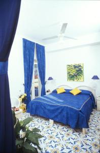 伊斯基亚Hotel La Sirenella的卧室内的一张带黄色枕头的蓝色床