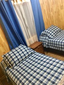奇廉Cabañas Alto Nativo的配有蓝色窗帘的客房内的两张床