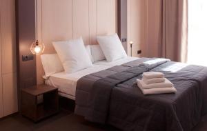 马拉加Apartamentos NONO by Charming Stay的一间卧室配有一张床,上面有两条毛巾