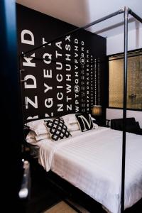 金宝康帕M精品酒店的一间卧室配有一张带黑白床头板的床
