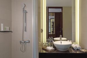 库塔巴厘岛金色郁金香继能度假酒店的一间带水槽和淋浴的浴室