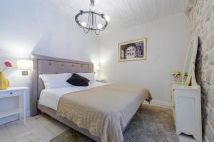 杜布罗夫尼克杜布罗夫尼克老度假屋的一间卧室配有一张大床和一个吊灯。