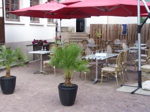 Vallon-en-Sullyle lichou的一个带桌椅和红色遮阳伞的庭院
