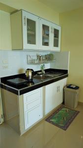 班佩410罗勇贵宾公寓的厨房配有白色橱柜和水槽