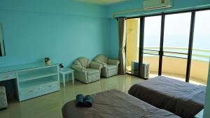 班佩410罗勇贵宾公寓的酒店客房设有两张床、一把椅子和电视。
