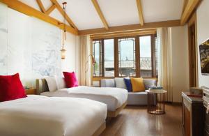 丽江丽江古城英迪格酒店的酒店客房,设有两张床和一张沙发