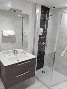 罗德兹Logis Hôtel du Midi - Rodez Centre-Ville的带淋浴、盥洗盆和淋浴的浴室