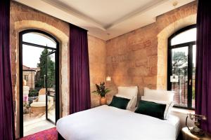 耶路撒冷Villa Brown Jerusalem, a member of Brown Hotels的卧室设有白色大床和窗户。