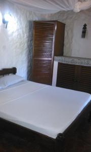 迪亚尼海滩迪亚尼班达旅馆的卧室配有白色的床和木门