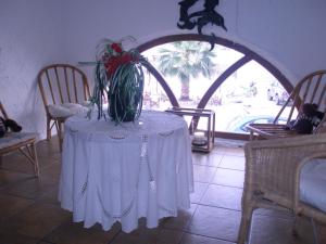 斯科拉Captain's House Hotel的一张桌子,上面有白色的桌布和植物