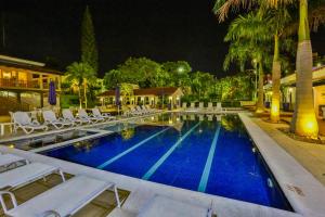 马里利亚Sun Valley Marília by Atlantica的一个带白色躺椅的游泳池,晚上则提供度假胜地