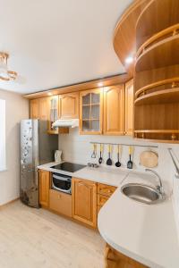 苏梅VIP Apartment ob Gorkogo Square的厨房配有木制橱柜和不锈钢冰箱。