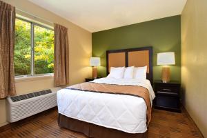 地球城Extended Stay America Select Suites - St Louis - Earth City的一间卧室设有一张大床和一个窗户。