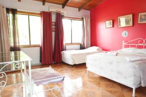 利比里亚阿瑞纳酒店的一间带两张床和红色墙壁的卧室
