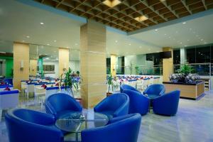 加拉旺BATIQA Hotel & Apartments Karawang的大楼内带蓝色桌椅的大堂