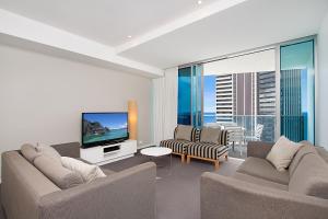 黄金海岸Orchid Residences - HR Surfers Paradise的客厅配有2张沙发和1台平面电视