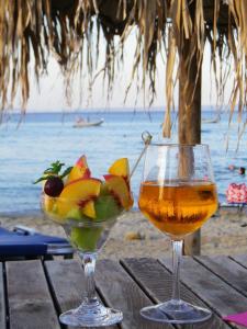 波利克罗诺尼莫一室公寓的海滩上的桌子上放着饮料和一碗水果
