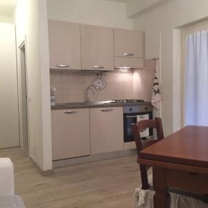 蓬塔阿拉Ala Garden Apartment的厨房配有白色橱柜、桌子和用餐室。